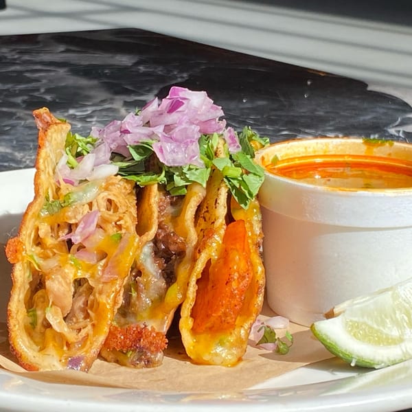 Three Pretty Little Tacos with red onions, cilantro, and a side of consommé and lime.